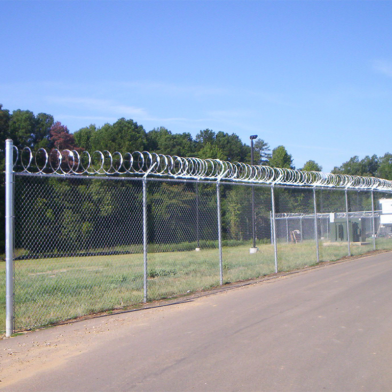 tall silver chain link fence with coiled barbed wire